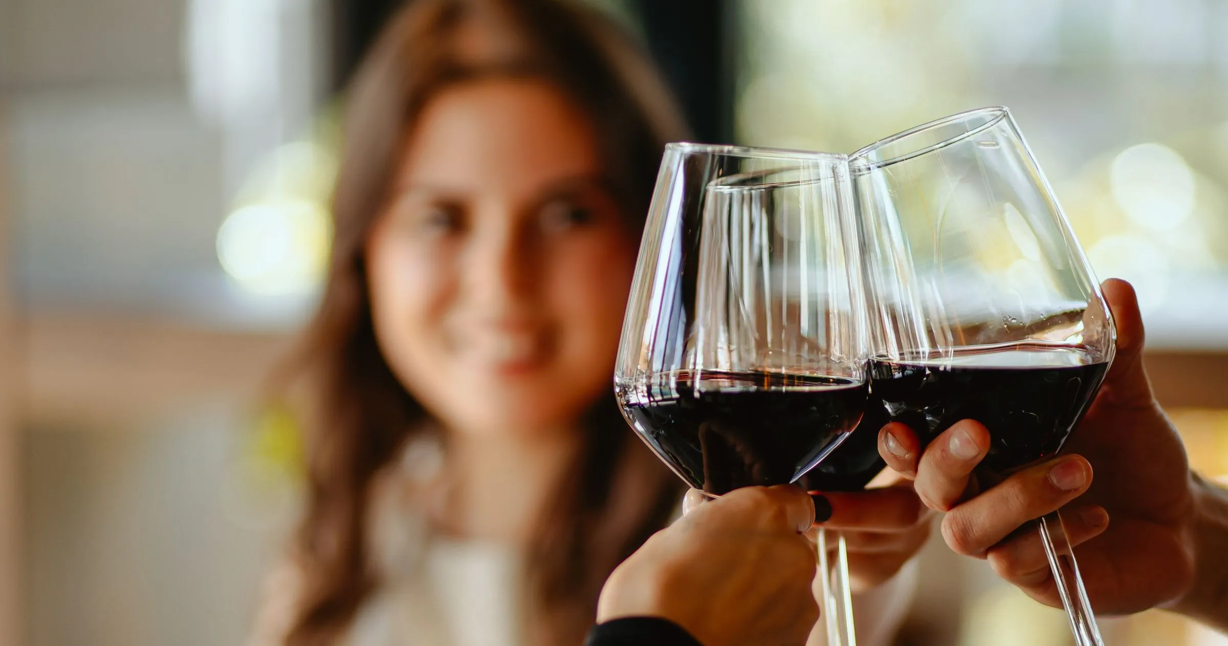 Gošća i gost nazdravljaju čašama crnog vina u restoranu Žar&So