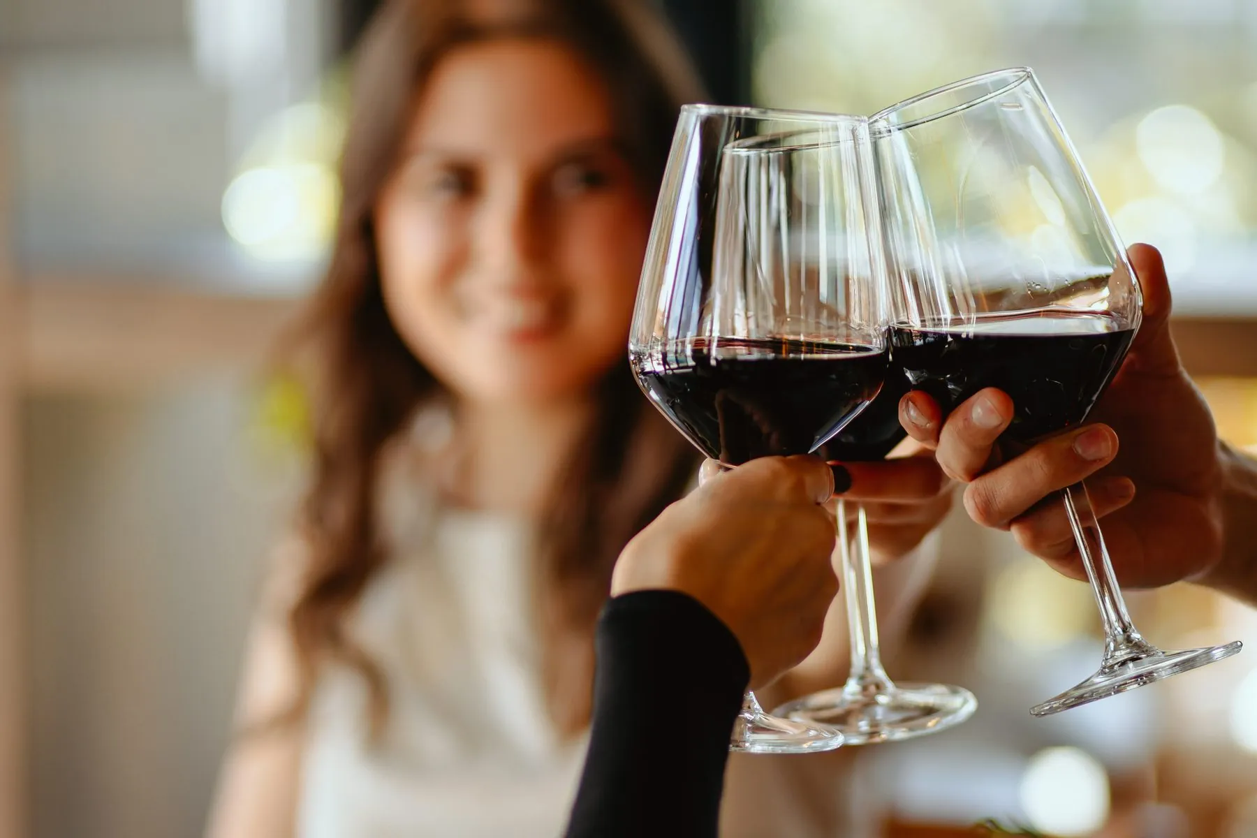 Nazdravljanje čašama crnog vina u restoranu