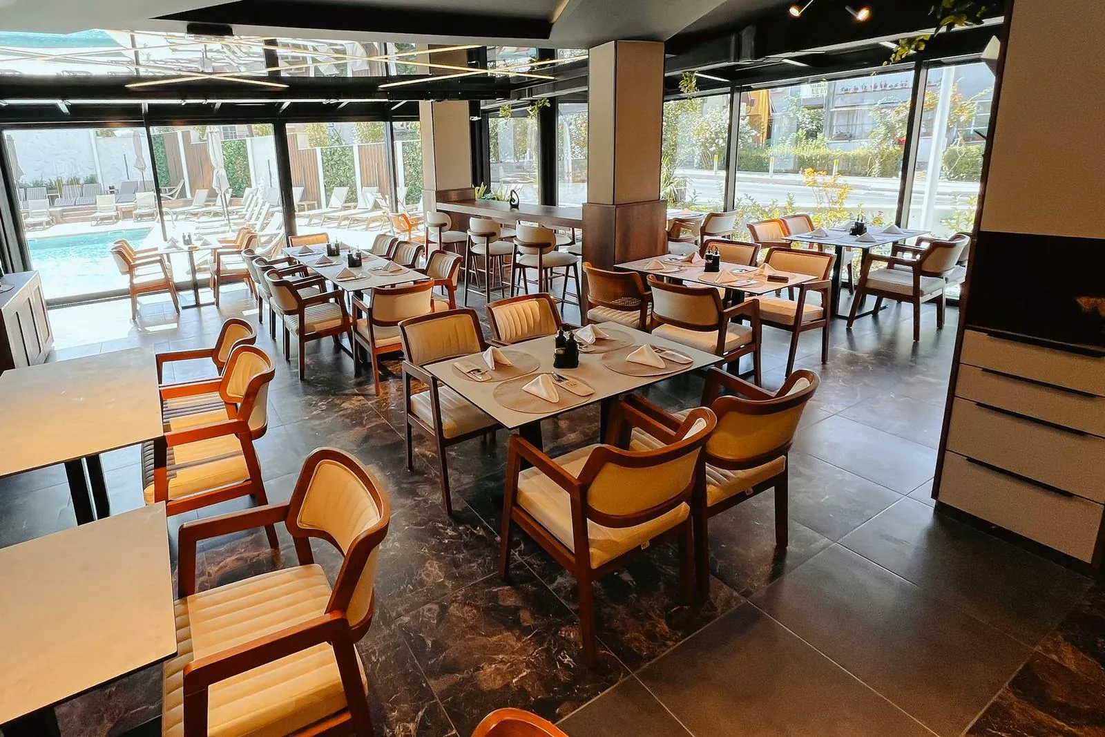 Sala restorana sa staklenim zidom i pogledom na bazen